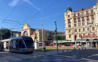 a tram on a street in front of a building at À 2 pas du centre in Nice