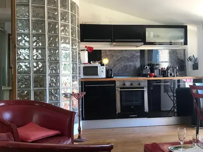 a kitchen with black appliances and a red chair at Balcony last floor harbour Nice parking on demand in Nice