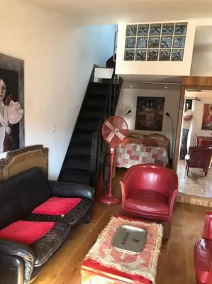 a living room with a couch and a chair and a staircase at Balcony last floor harbour Nice parking on demand in Nice
