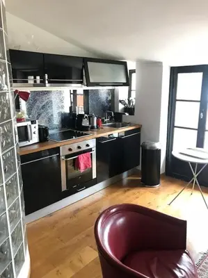 a kitchen with black cabinets and a stove top oven at Balcony last floor harbour Nice parking on demand in Nice