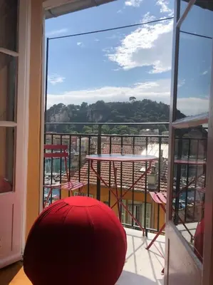 a red ball sitting on a balcony looking out a window at Balcony last floor harbour Nice parking on demand in Nice