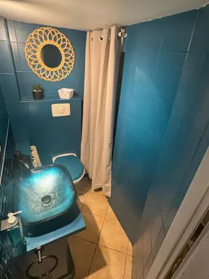 a blue bathroom with a sink and a toilet at Duplex proche port de Nice in Nice