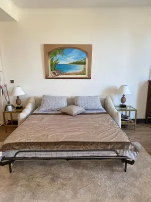 a bedroom with a bed with a painting on the wall at Magnifique villa pieds dans l eau Saint Jean Cap Ferrat in Saint-Jean-Cap-Ferrat
