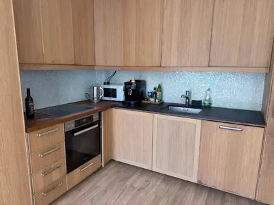 a kitchen with wooden cabinets and a sink and a microwave at Magnifique villa pieds dans l eau Saint Jean Cap Ferrat in Saint-Jean-Cap-Ferrat