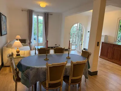 a dining room with a table and a living room at Magnifique villa pieds dans l eau Saint Jean Cap Ferrat in Saint-Jean-Cap-Ferrat