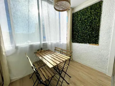 a table and chairs in a room with a green wall at Azur & Chill - à proximité Mer Train Bus Aéroport in Saint-Laurent-du-Var