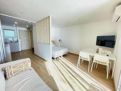 a living room with a table and a bedroom at Azur & Chill - à proximité Mer Train Bus Aéroport in Saint-Laurent-du-Var