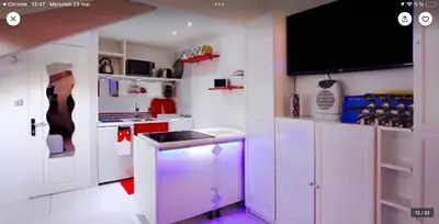 a kitchen with white cabinets and a tv on the wall at Studio atypique central mais calme, quartier VIP, plage 50m in Nice