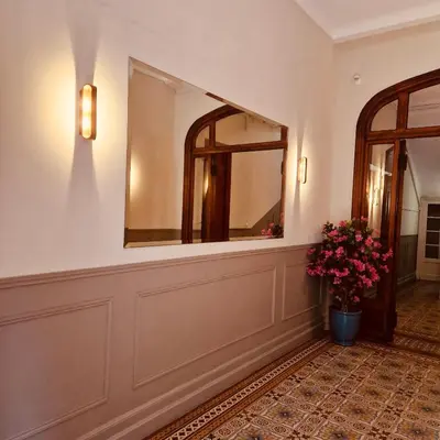 a hallway with a mirror and a vase of flowers at Studio atypique central mais calme, quartier VIP, plage 50m in Nice