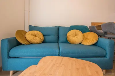 a living room with a blue couch and a table at Magnifique 2 pièces, Clim, parking , wifi in Beaulieu-sur-Mer
