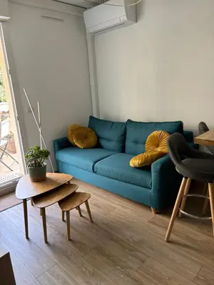 a blue couch with two pillows on top of it at Magnifique 2 pièces, Clim, parking , wifi in Beaulieu-sur-Mer