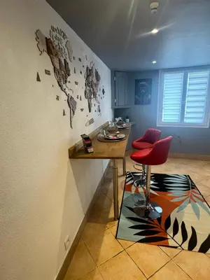 a dining room with a table and a red chair at Appartement en duplex in Nice