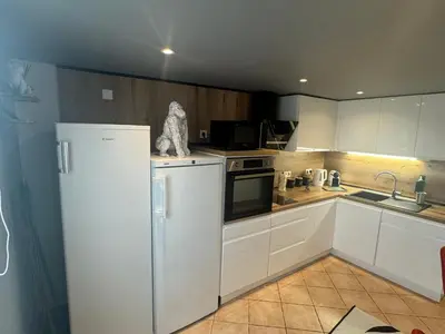 a kitchen with white cabinets and a refrigerator at Appartement en duplex in Nice