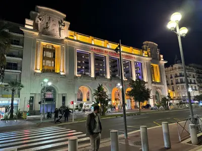 a man standing in front of a building at night at Appartement en duplex in Nice