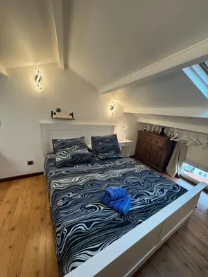 a bedroom with a large bed with a blue blanket at Appartement en duplex in Nice