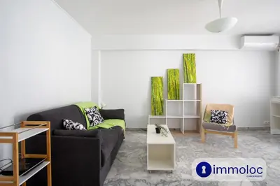 a living room with a couch and a table at Studio Air-conditioned district of the Musicians in Nice