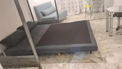 a bed in a room with a couch and a chair at Petit studio promenade des Anglais in Nice
