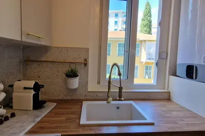 a kitchen with a sink and a large window at Rêves d'Orient - proche mer in Nice
