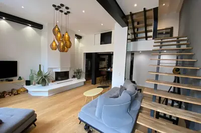 a living room with a blue couch and a staircase at 06BX Loft Pessicart in Nice