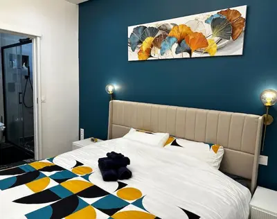 a bed with a teddy bear sitting on top of it at Chic Renovated Home - Nice Libération - Entire 2BR 2BA Apartment or Private Rooms with Private Bathrooms - AC and Garage on request in Nice