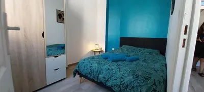 a bedroom with a bed with blue sheets and a mirror at Charmant 2 pièces in Nice