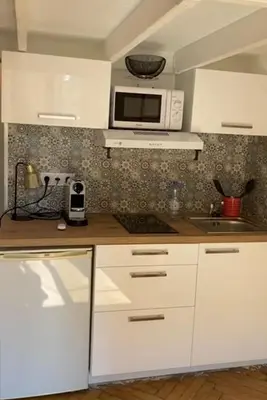 a kitchen with white cabinets and a microwave at Studio Hérold - Évasion avec Terrasse à Nice in Nice