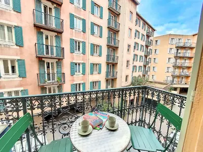 a table and chairs on a balcony with buildings at Nestor&Jeeves - PLACE DU PIN - Near Port - Old town in Nice