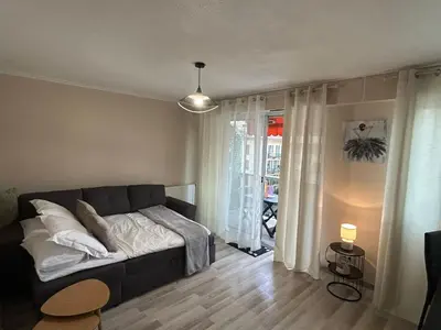 a living room with a couch in front of a window at Studio à deux pas de la mer in Nice
