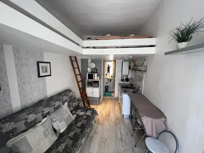 a living room with a couch and a table at Petit studio de charme in Villefranche-sur-Mer