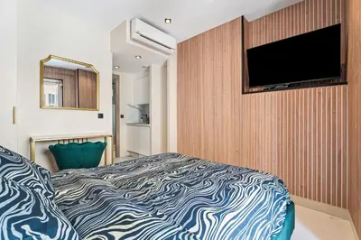 a bedroom with a bed and a flat screen tv at Nice Renting - 7FRANCE - Suite Luxe & Confort Bord de Mer Massena in Nice