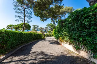 a path through a hedge with trees on the side at VILLA LA PETITE RESERVE VI4416 By Riviera Holiday in Èze