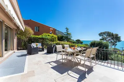 a patio with a table and chairs on a balcony at VILLA LA PETITE RESERVE VI4416 By Riviera Holiday in Èze
