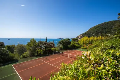 a tennis court with the ocean in the background at VILLA LA PETITE RESERVE VI4416 By Riviera Holiday in Èze