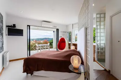 a bedroom with a bed and a red chair at VILLA ADRIANA VI4411 By Riviera Holiday Homes in Nice