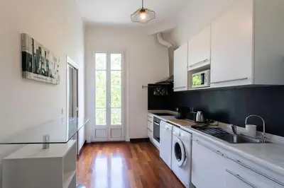 a kitchen with white cabinets and a black counter top at #27 Urban Suite AC 2 Bedrooms 10mins Walk Sea&Old Town in Nice