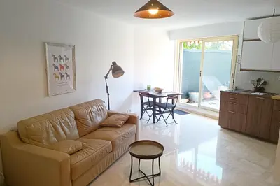a living room with a couch and a table at Refurbished apartment with terrace and garden in Nice
