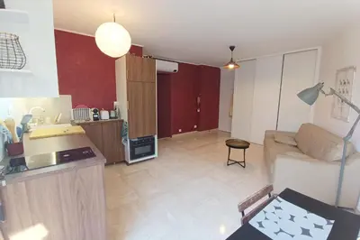 a large living room with a couch and a kitchen at Refurbished apartment with terrace and garden in Nice