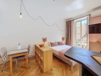 a bedroom with a bed and a table and a window at Nestor&Jeeves - CITY TRIP - Central - Balcony in Nice