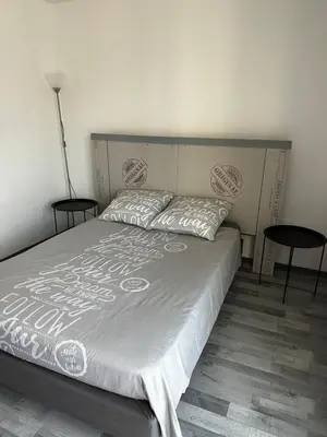 a bedroom with a large bed with two tables at Californie in Nice