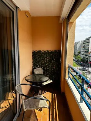 a balcony with two chairs and a table on a balcony at Californie in Nice