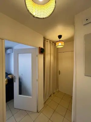 a hallway with a door and a chandelier at Studio proche promenade des anglais in Nice