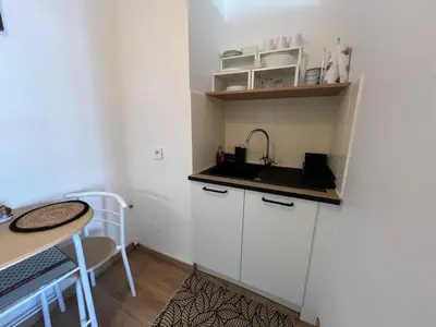 a small kitchen with a sink and a table at Studio proche promenade des anglais in Nice