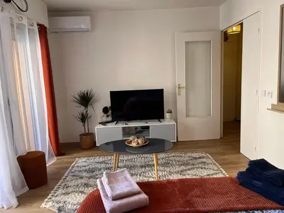 a living room with a tv and a table at Studio proche promenade des anglais in Nice