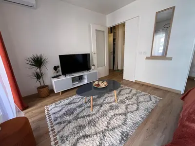 a living room with a tv and a table at Studio proche promenade des anglais in Nice