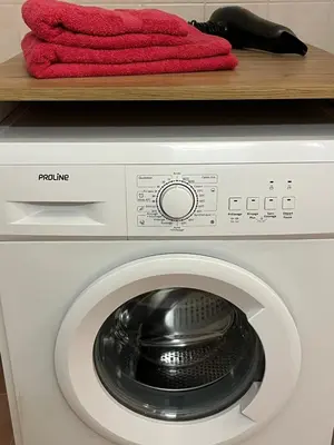a washing machine with a red towel on a shelf at Studio proche promenade des anglais in Nice