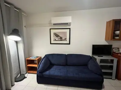 a living room with a blue couch and a television at Magnifique 2 pièces centre Nice in Nice