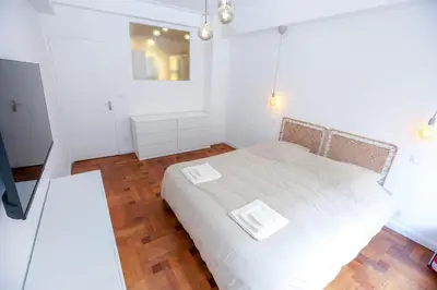 a bedroom with a white bed and a wooden floor at Nice carré d'or proche Negresco in Nice