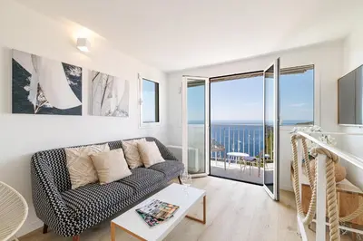 a living room with a couch and a view of the ocean at 73 CORNE D OR - Duplex plein SUD, VUE MER, BALCON in Villefranche-sur-Mer