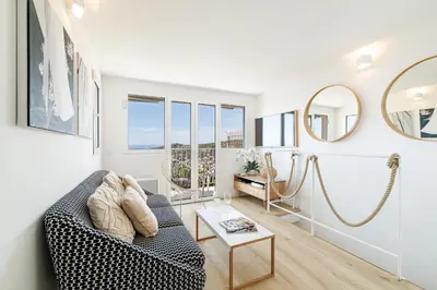 a living room with a couch and a table at 73 CORNE D OR - Duplex plein SUD, VUE MER, BALCON in Villefranche-sur-Mer