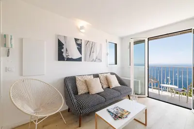 a living room with a couch and a table at 73 CORNE D OR - Duplex plein SUD, VUE MER, BALCON in Villefranche-sur-Mer